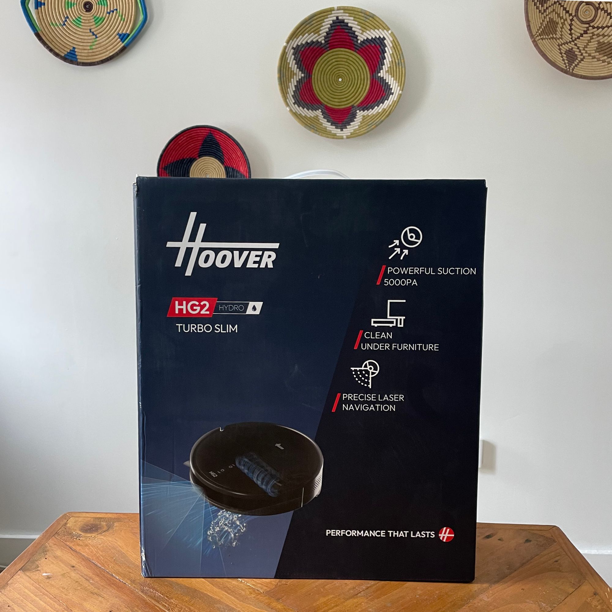 Hoover HG2 robot vacuum and mop box sitting on a wooden table
