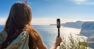Insta360 One X4 8K 360 camera held on an invisible selfie stick to capture seaside panarama