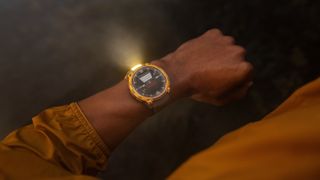 A photo of the Garmin Instinct Crossover AMOLED watch with the flashlight active on a person's wrist at night