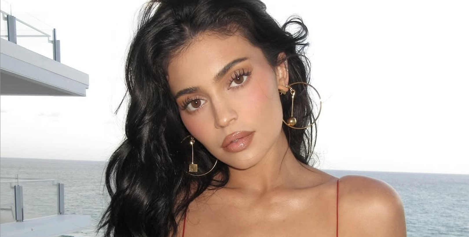 kylie jenner wears a red spaghetti strap dress in miami with jacquemus clutch and earrings
