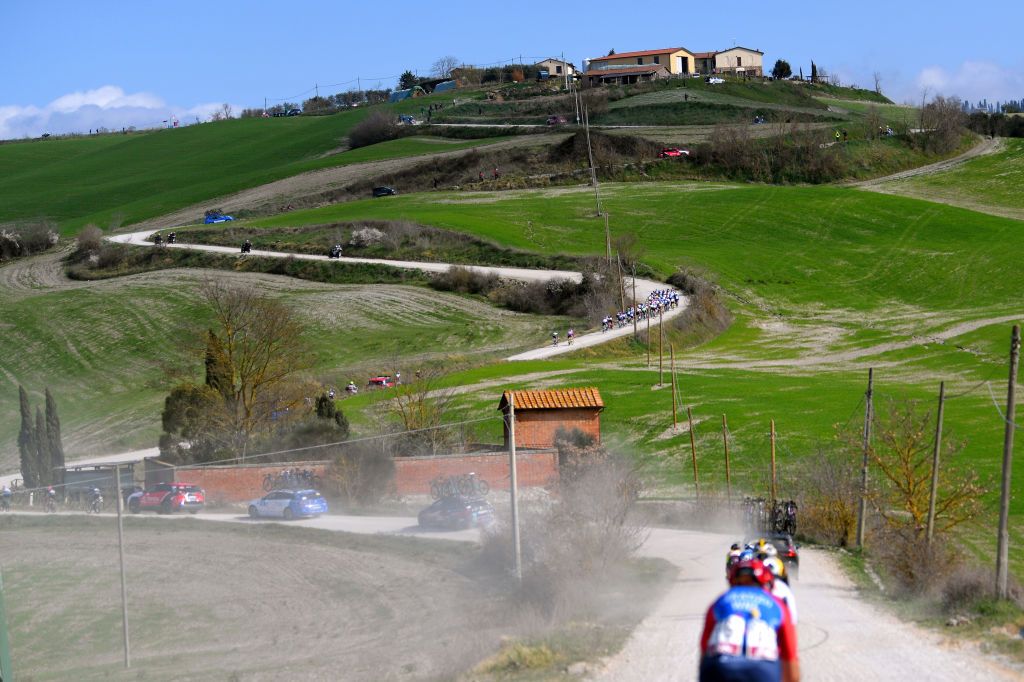 SIENA ITALY MARCH 06 The Peloton passing through Tuscany landscape during the Eroica 7th Strade Bianche 2021 Womens Elite a 136km race from Siena to Siena Piazza del Campo Dust Gravel strokes StradeBianche on March 06 2021 in Siena Italy Photo by Luc ClaessenGetty Images