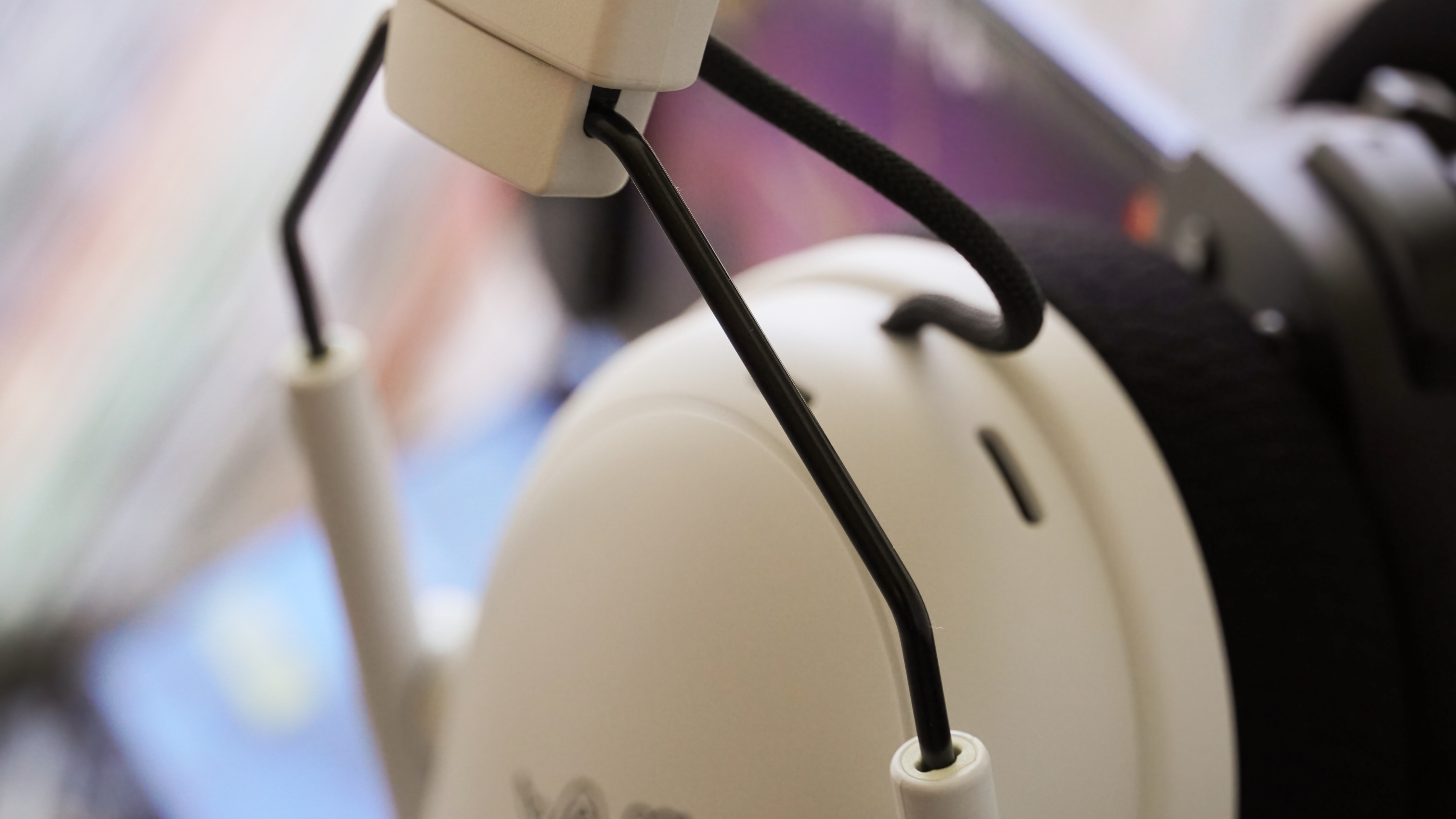 The Razer BlackShark V3 Pro gaming headset laid atop records showing the metal adjustment slider.