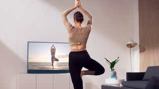 Woman practises yoga in front of Sky Glass