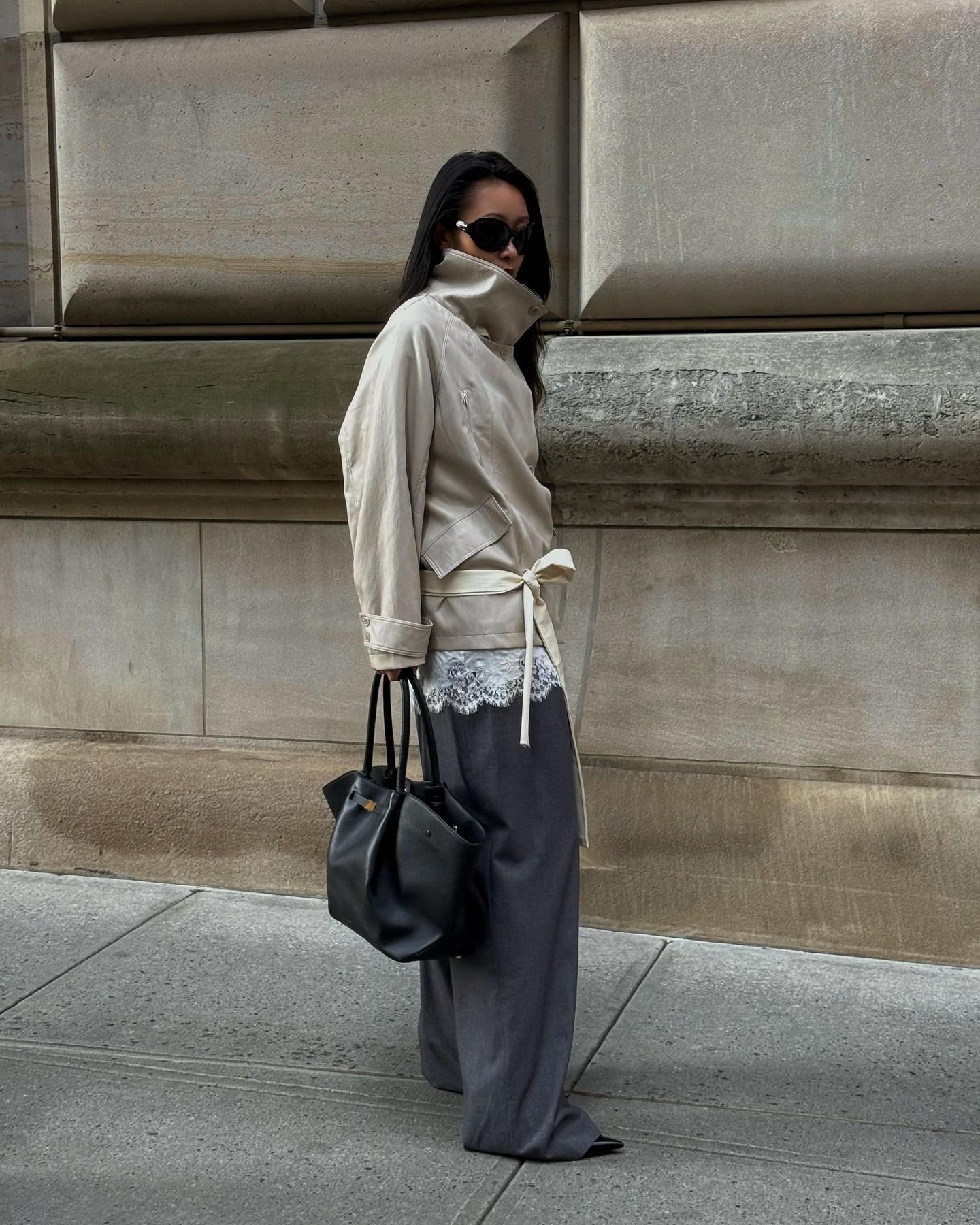 An image @thecarolinelin wearing a cropped trench coat, one of the biggest trends making a comeback for winter 2025, with a lace trim and tailored trousers.