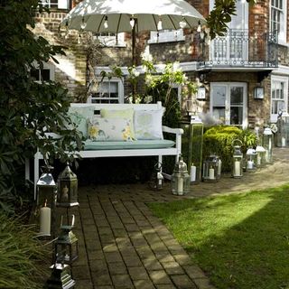 garden area with white bench and lanterns