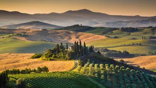 a view of tuscany at sunset
