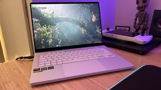 Asus ROG Zephyrus G14 running Shadow of the Tomb Raider benchmark on a wooden desk