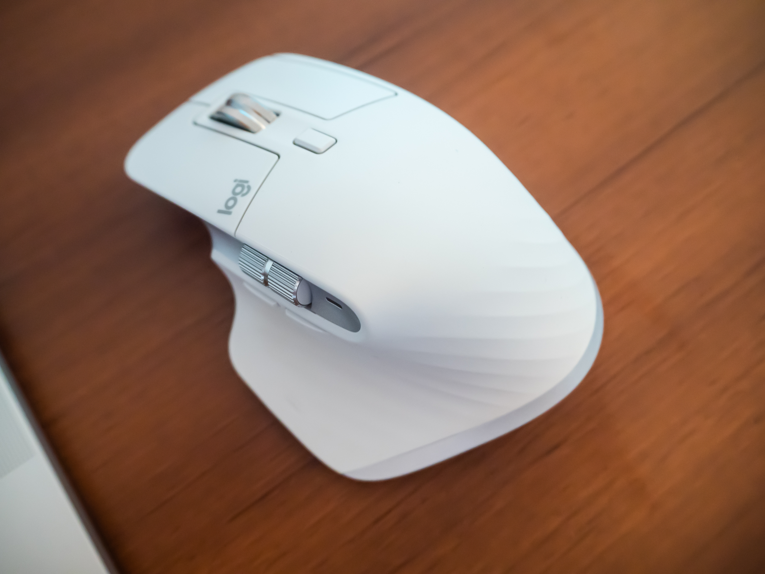 A white Logitech MX Master 3S for Mac mouse on a brown wooden desk