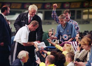 England captain Alan Shearer signs autographs for fans at his unveiling as a Newcastle United player for a then World Record fee of £15 Million at St James' Park as Freddie Fletcher (bottom) looks on, on July 30, 1996 in Newcastle Upon Tyne, England.