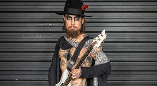 Jane's Addiction's Dave Navarro is open-shirted, wearing a flower in his hat as he is photographed with his signature PRS electric guitars