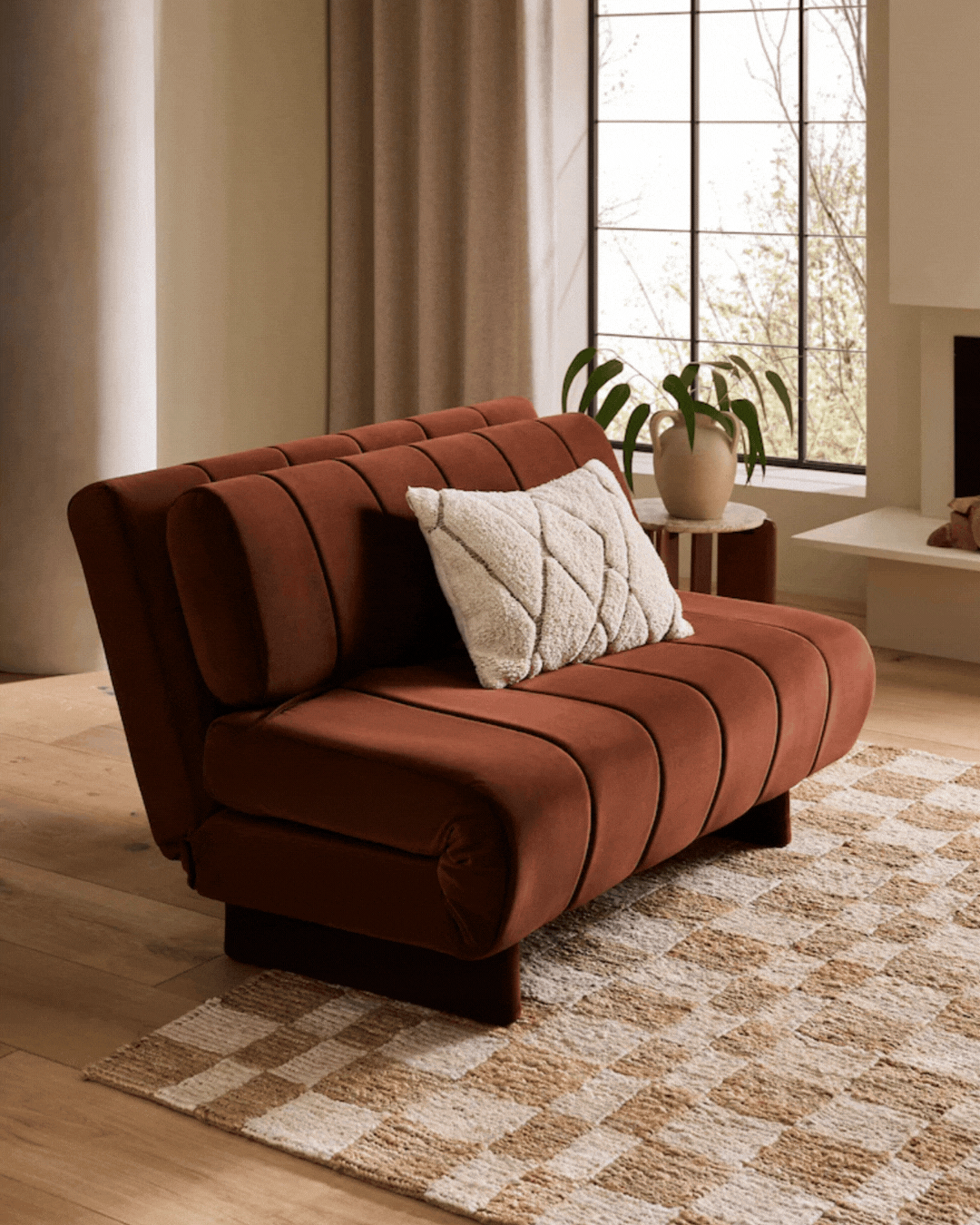 Soft Velvet Rust Brown Daphne Double Sofa Bed in a neutrally painted living room, captured in a rotating gif showing it open and folded.