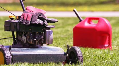 Lawn mower on lawn with a canister of oil