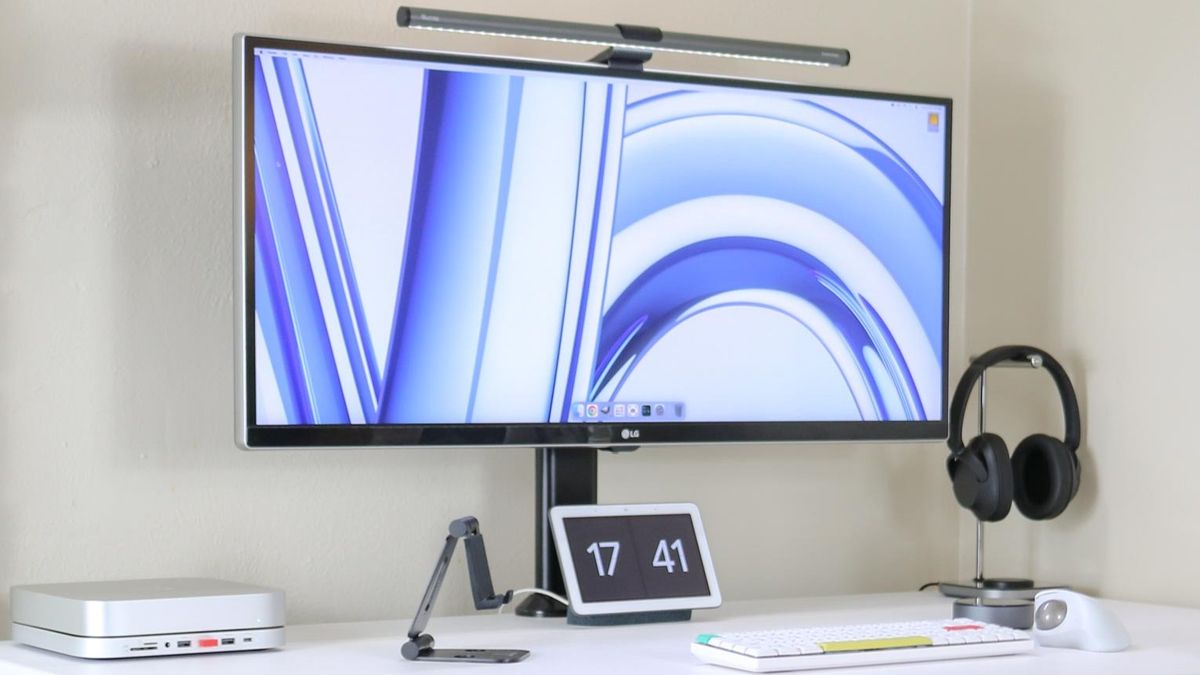 A Mac mini M2 on a desk with a monitor keyboard and other accessories