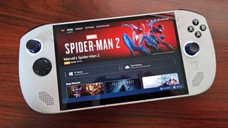 Lenovo Legion Go S with Legion Space software featuring Spider-Man 2 artwork on screen lying on woodgrain desk