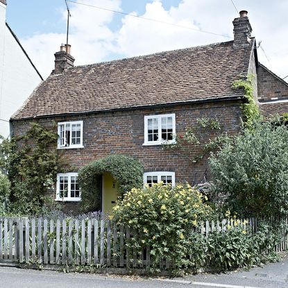sloping roof house with white windows and chimney stack