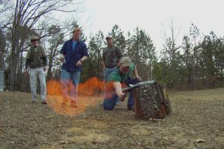 Rog ignites a test rocket using the gangs moonshine which Travis holds in the background