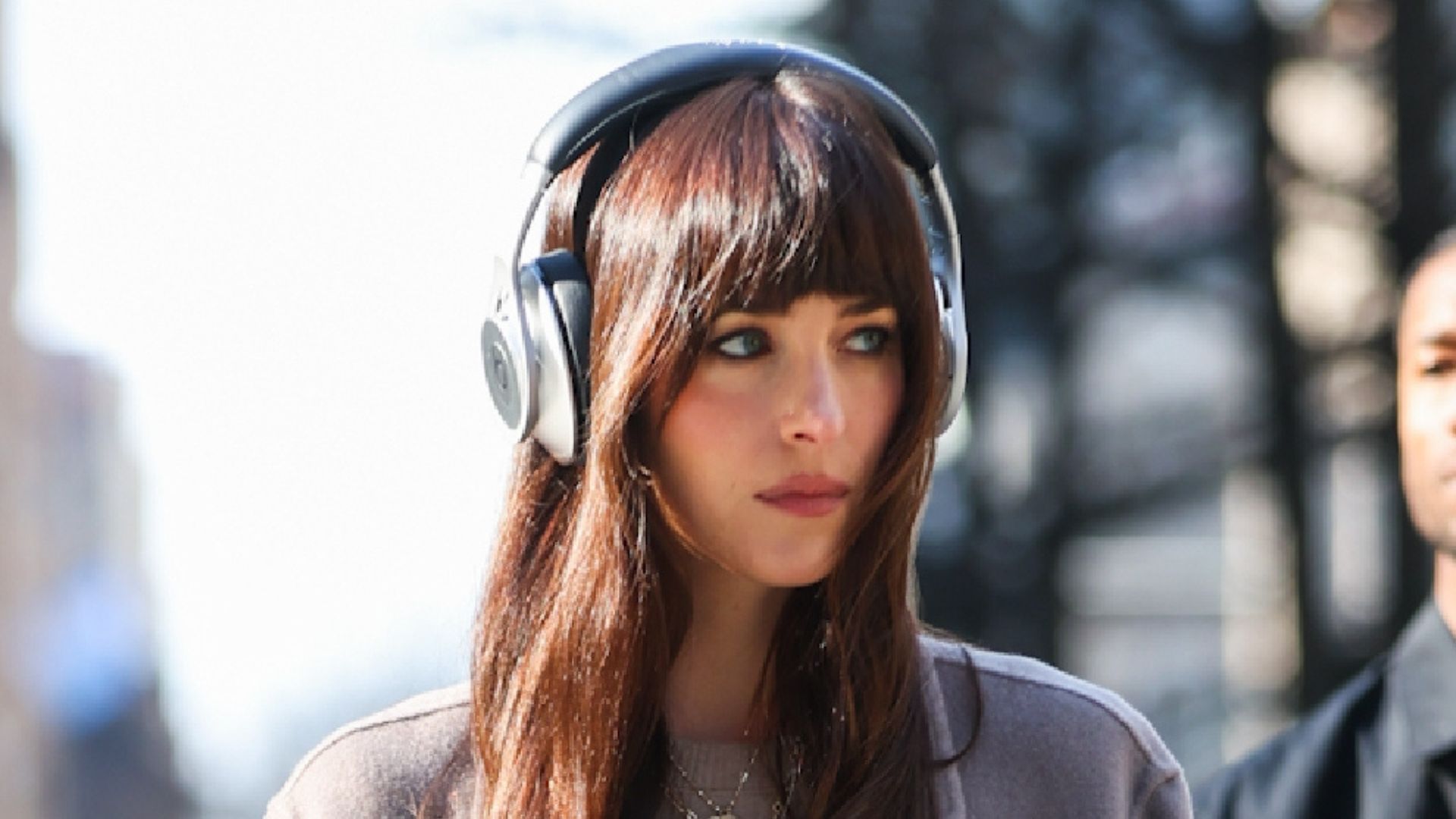 Dakota Johnson wearing taupe coat and burnt orange jeans on the set of Verity on March 12, 2025 in New York