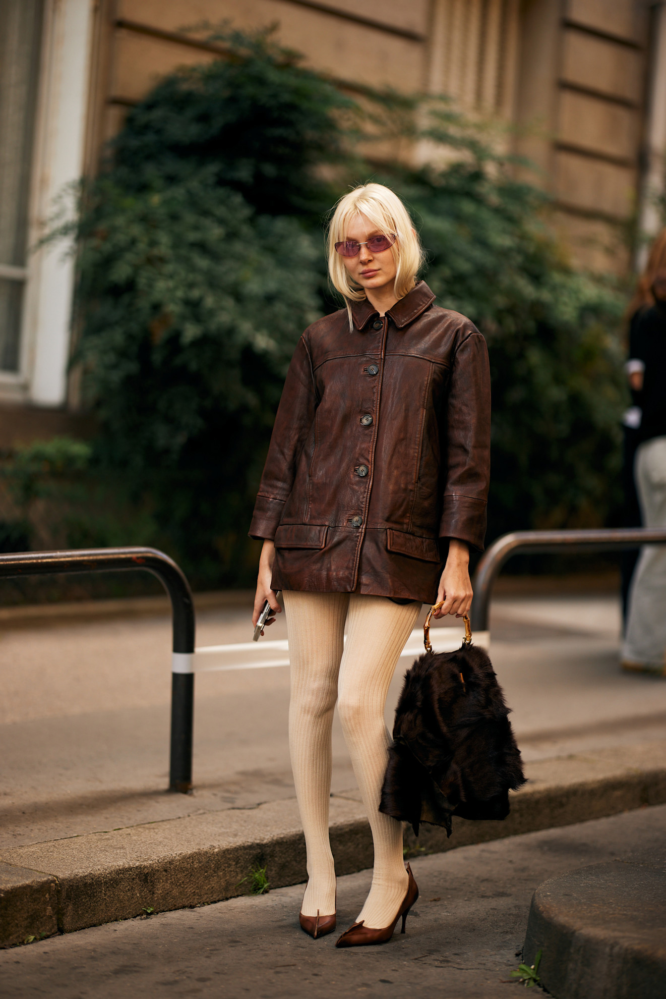 Fur accessory trend is shown in a street style photo of a woman