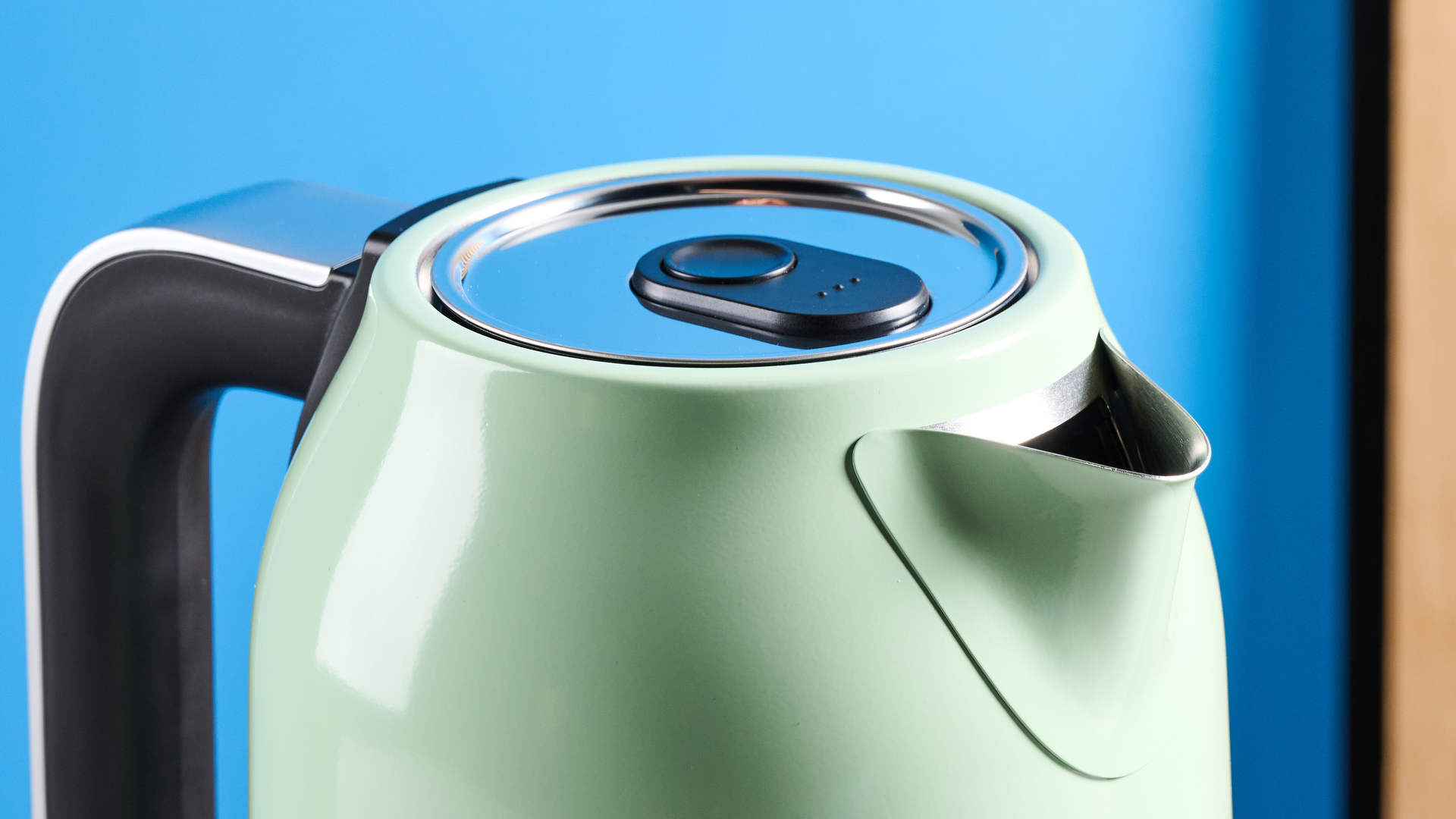 the kitchenaid 1.7L kettle in pistachio photographed on a white marble counter with a blue background