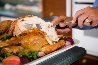 To cool a turkey to store for leftovers, your safest bet is to cut all of the meat off the bones.