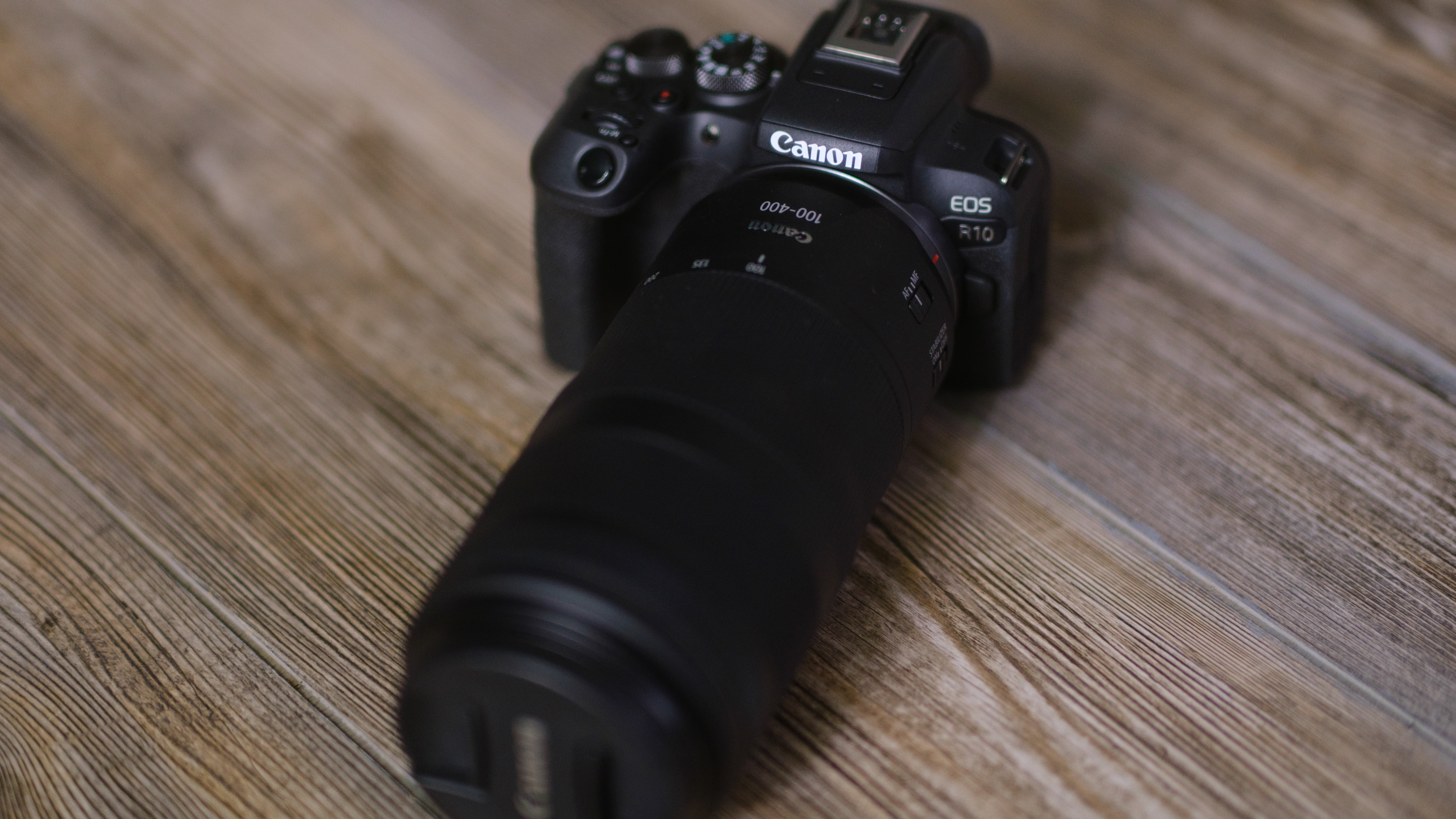 The Canon EOS R10 on a wood surface