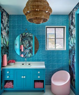 bathroom with bright blue cabinets and pink chair and accents