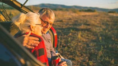 Senior couple outdoors with car 