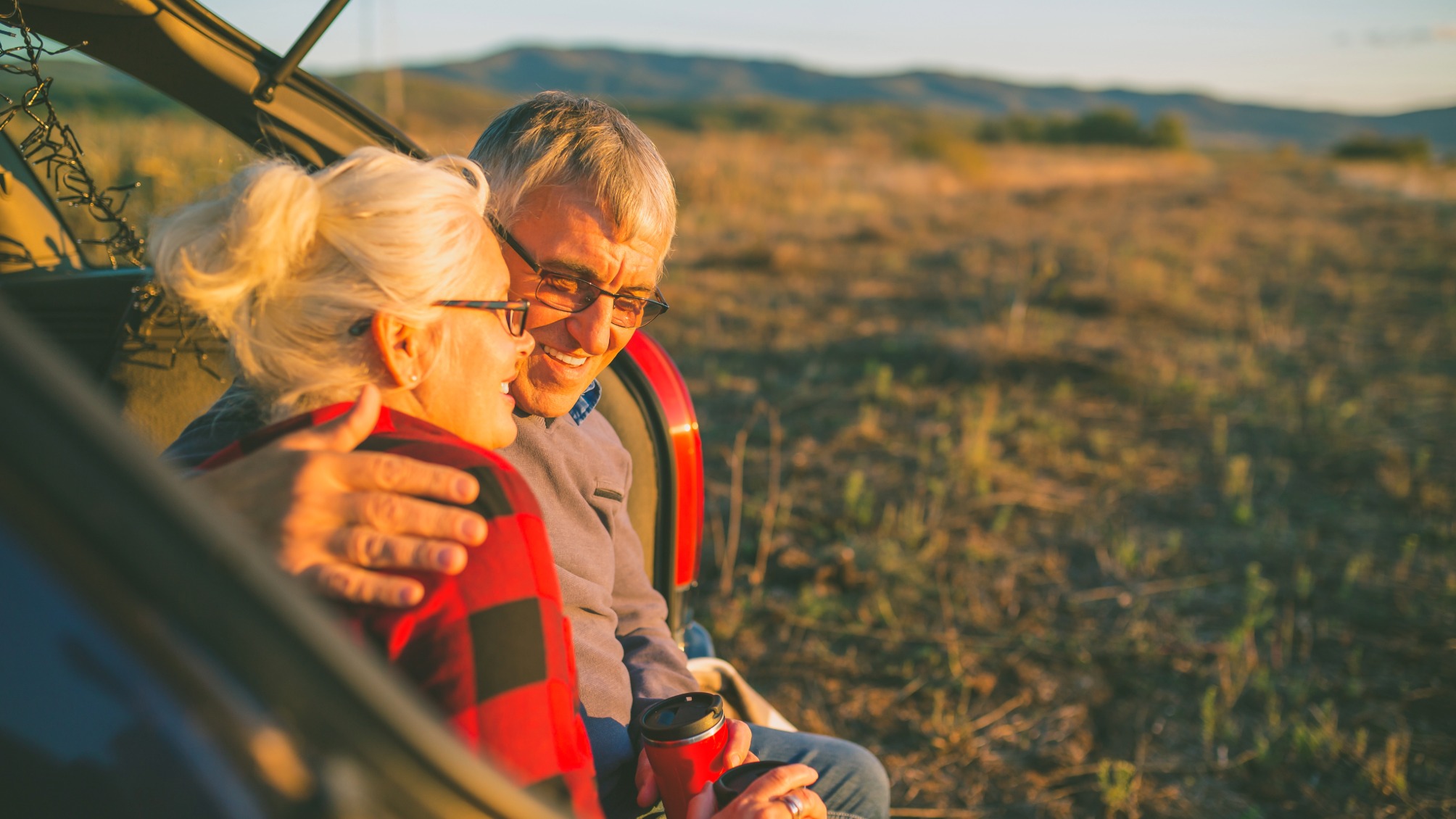 Senior couple outdoors with car 