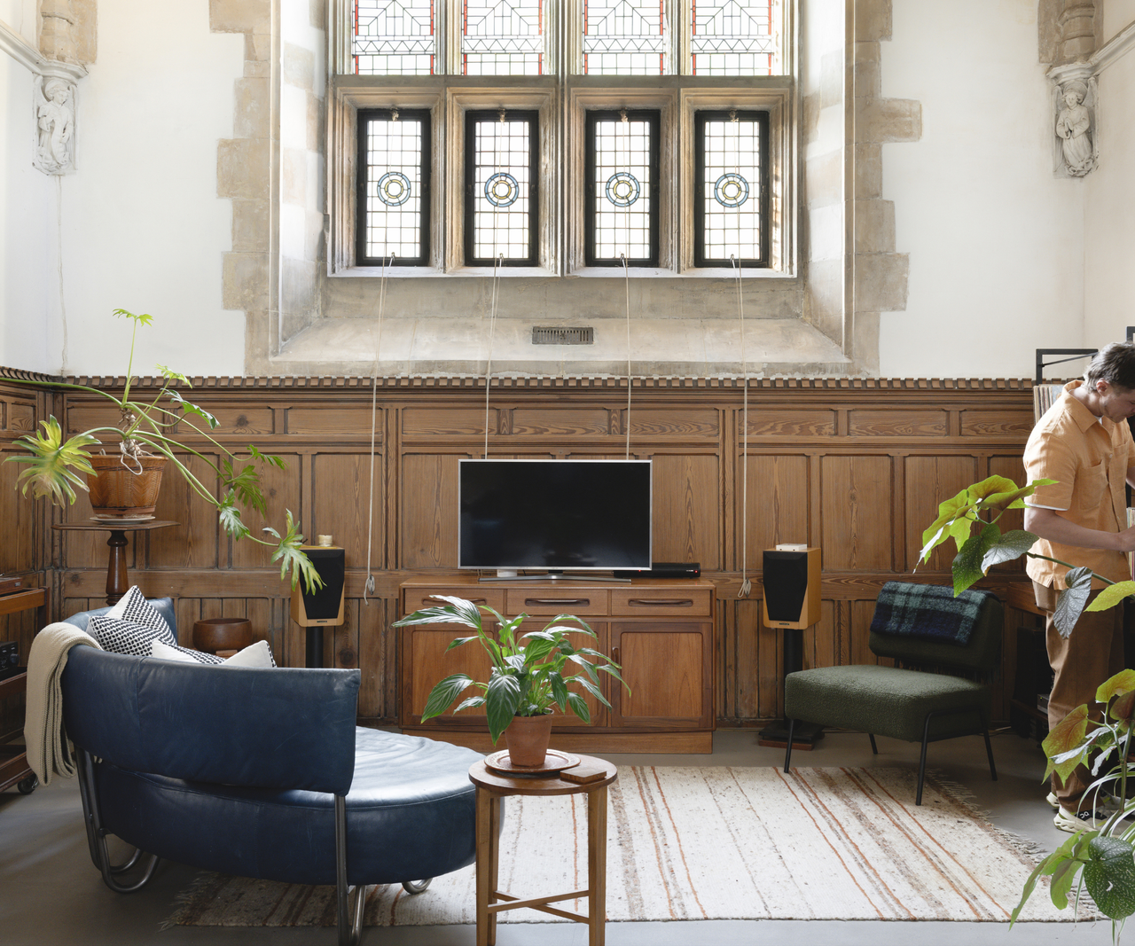 Living room area with wooden panelling and stained glass window