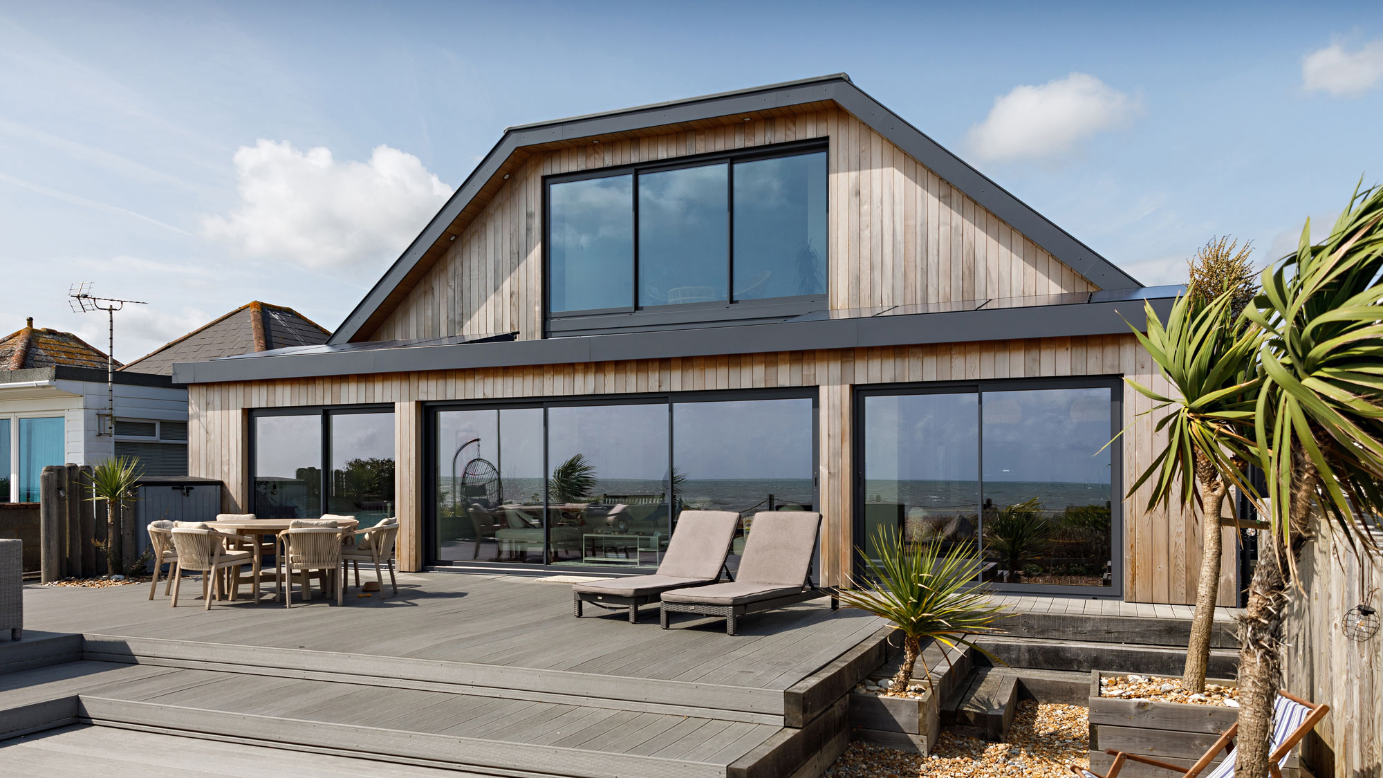 modern renovated dormer bungalow with vertical timber cladding and large sliding doors