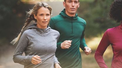 Best winter running tops: pictured here, women and men running on road in brooks running tops