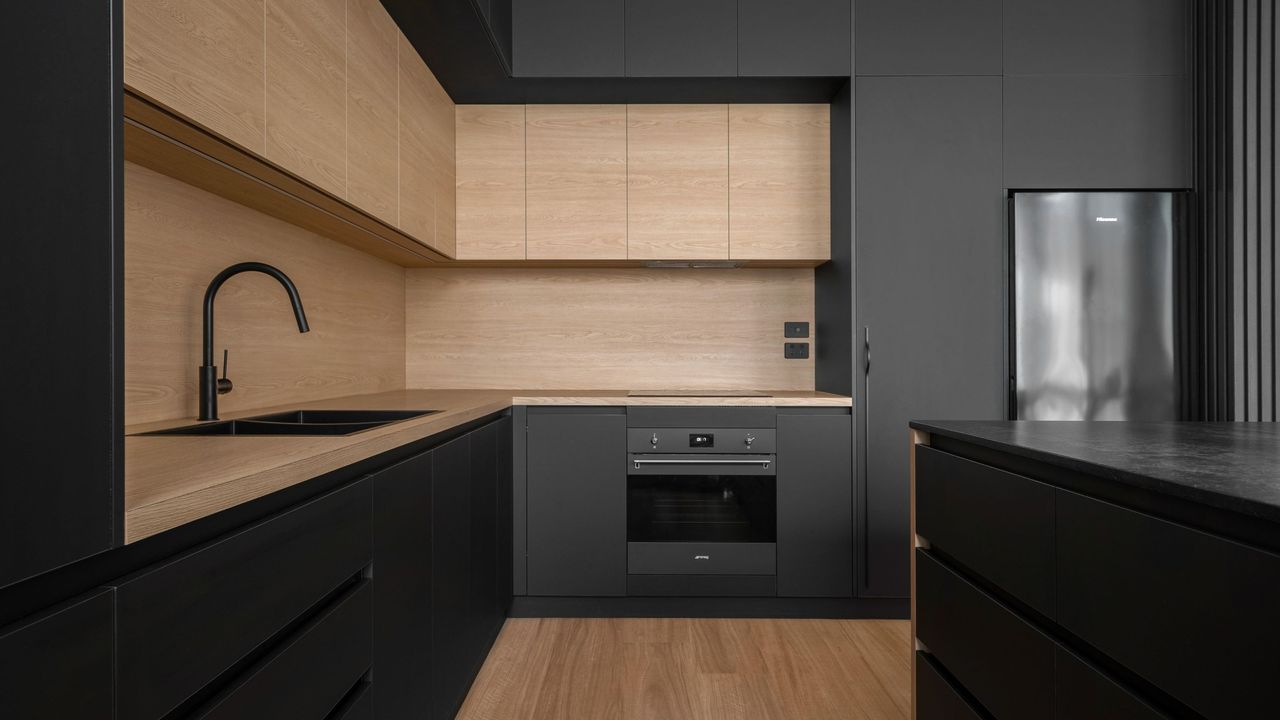 black kitchen with timber upper cabinets and timber flooring