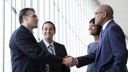 Businesspeople close a deal by shaking hands