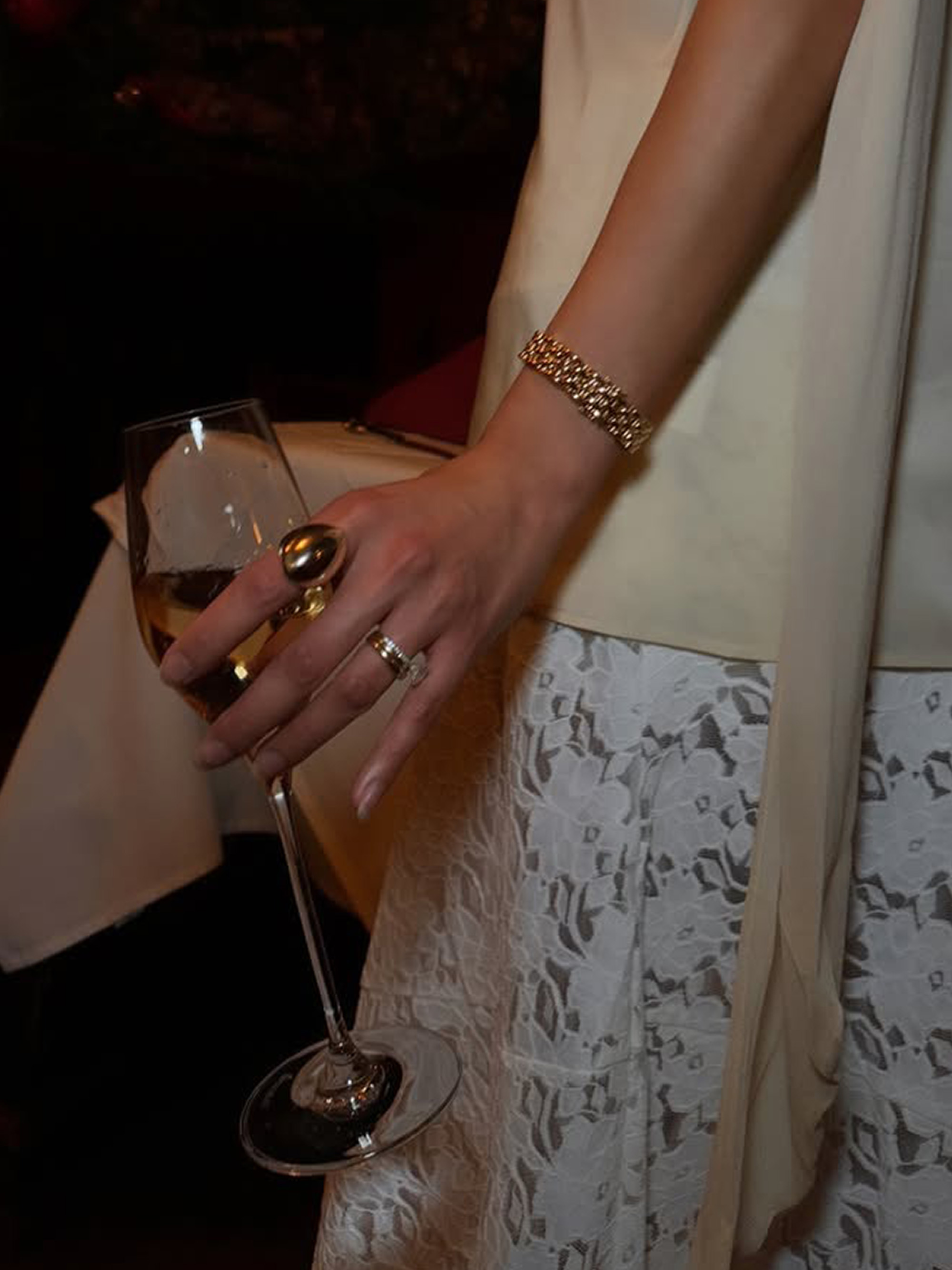 Dawn Tan holding a glass of champagne in her manicured hands.