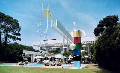The 1986 house’s rectangular sunscreen represents a beach umbrella, while the pool area is framed by two sculptures 
