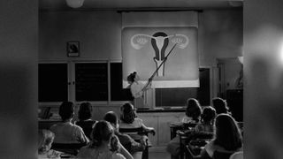 A teacher points to a diagram of female reproductive organs projected on a screen in a classroom in a scene from Human Growth, an education film on sex education shown to students in Oregon junior high schools beginning in 1948.