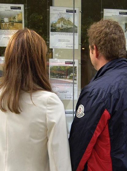 Couple looking at estate agent window