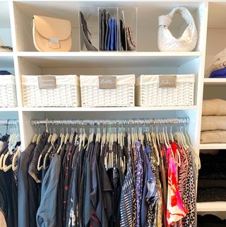 Storage baskets and hanging clothes in closet