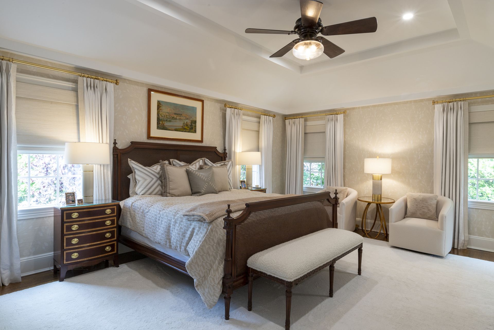 A neutral bedroom with a large bed, a cream carpet and white curtains