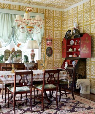 Dining room with treillage style wallpaper and vintage furniture