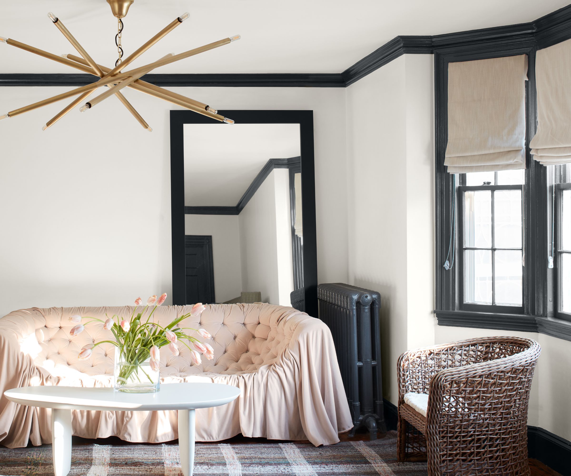 white living room with pink sofa and big gold light