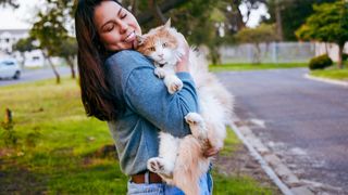 Cat being hugged by woman