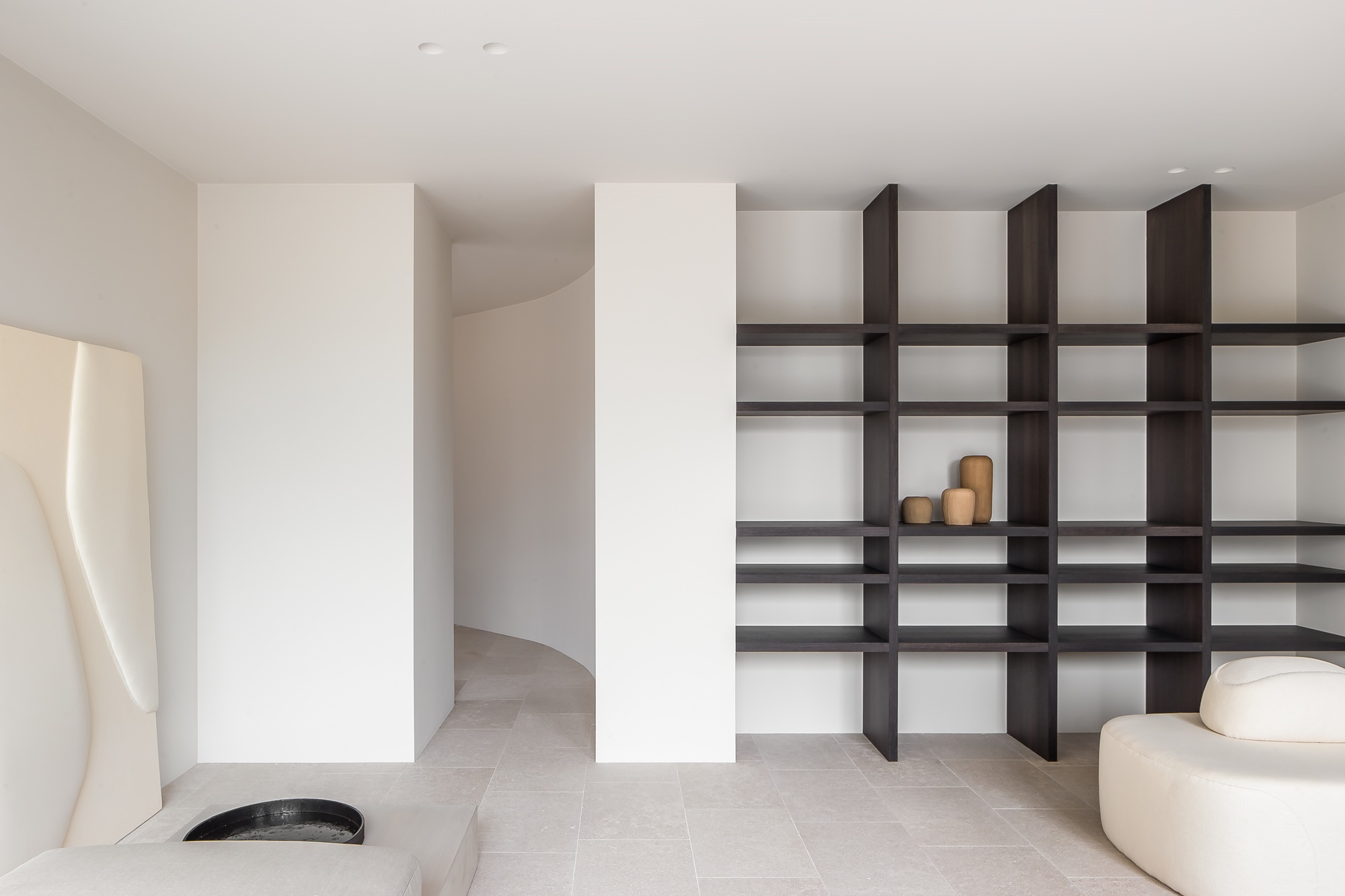a minimalist white apartment with wood shelving