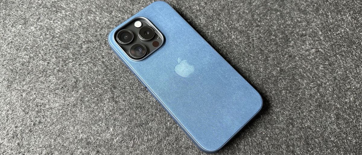 The iPhone 15 Pro with a Pacific Blue Apple FineWoven case on.