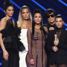 Kendall Jenner, Khloe Kardashian, Kim Kardashian, Kris Jenner, and Kourtney Kardashian onstage, and Prince Harry smiling, whom one of them was almost set up with