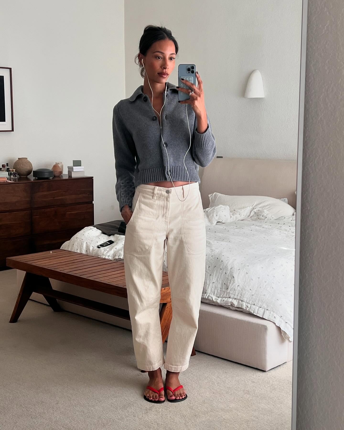 Woman in flip flops, cream jeans, and cardigan