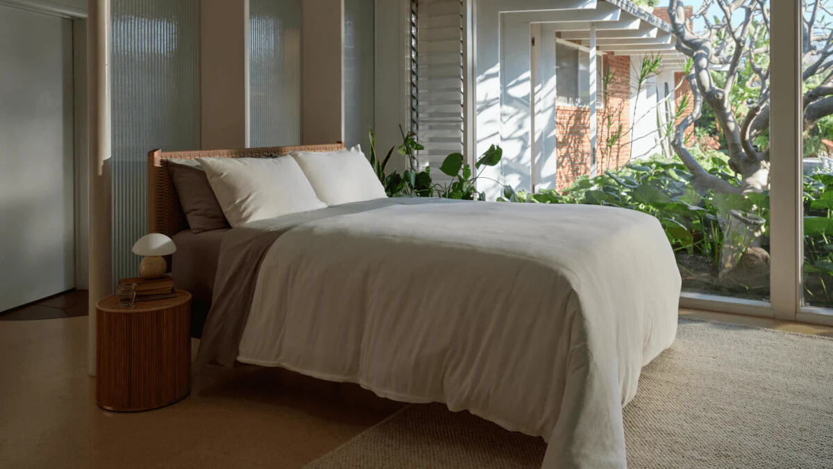 A bed in a brightly lit room dressed in the new Linen-Cotton bedding range from Coop