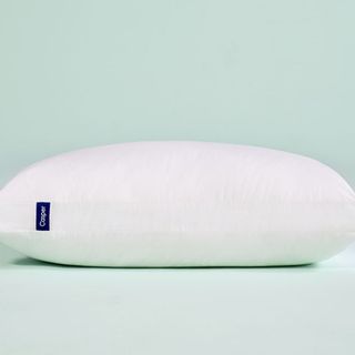 Casper Sleep Essential Pillow against a blue background.