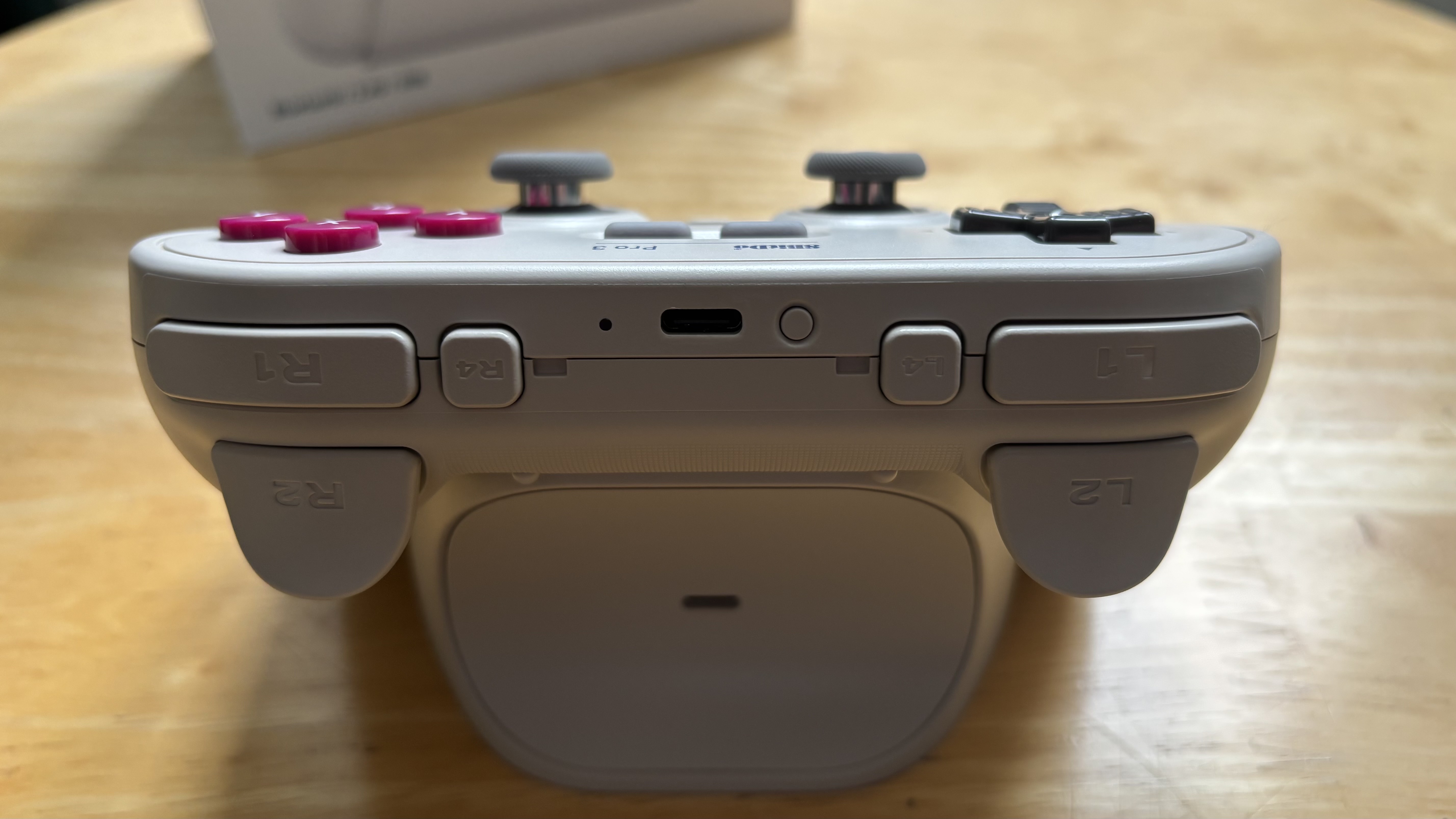 The 8BitDo Pro 3 controller photographed on a wooden table.