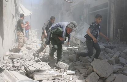 Syrians evacuate an injured man after an airstrike